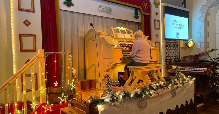 woman playing the Mighty Wurlitzer organ during a Christmas event